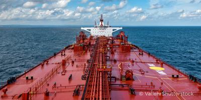 Close up of large blue merchant crago ship in the middle of the ocean underway. Performing cargo export and import operations with sun rays, horizon line and beautiful sky.; Shutterstock ID 1468222610; purchase_order: Graphics; job: ; client: Chris Reeves; other: 