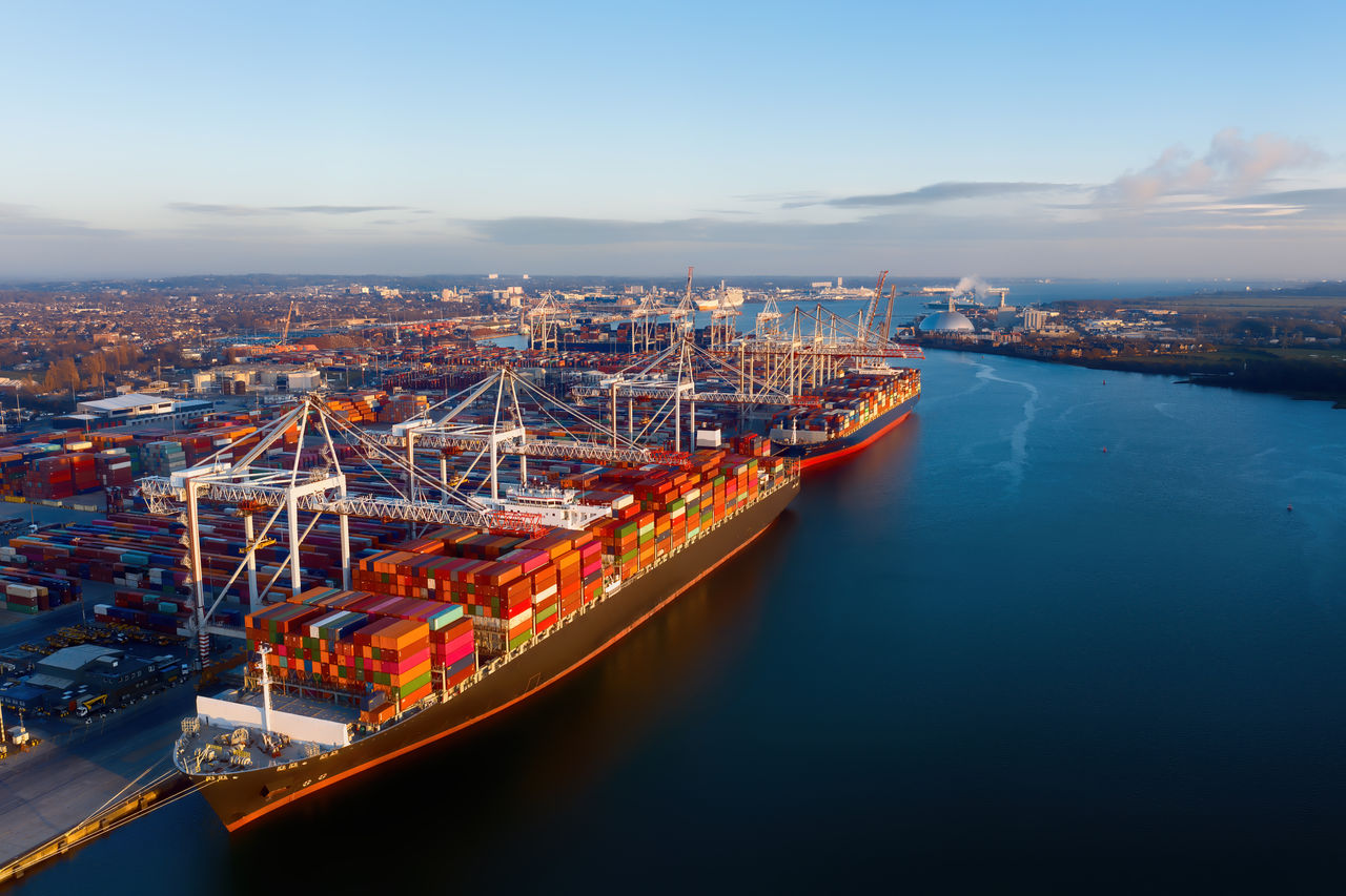 Aerial view of colorful containers on cargo ships at the port of Southampton, which is one of the Leading Port Terminal Operators in the UK. Containers on the dock too. Space for text.